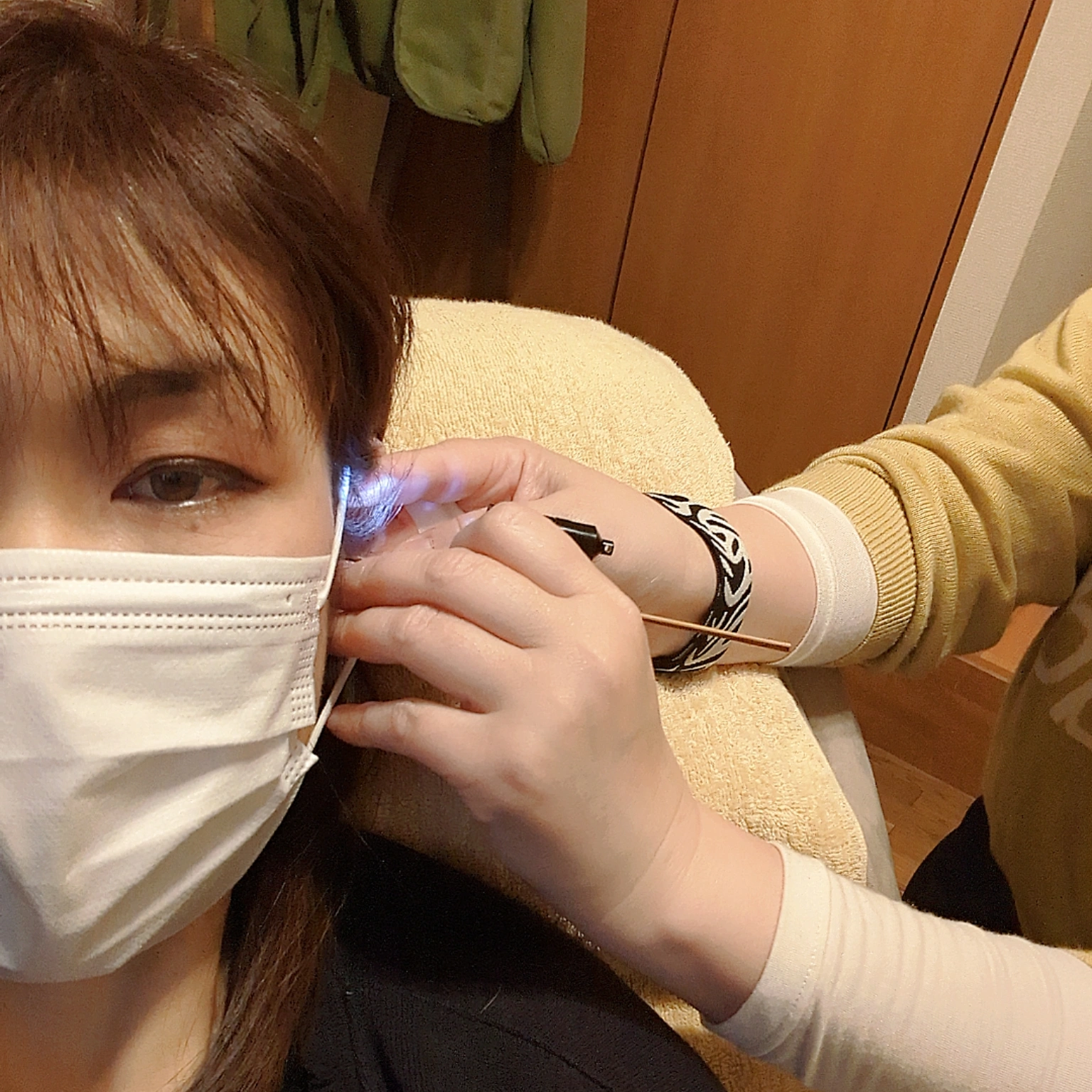 耳にライトを当てながら耳かきの手順を学ぶ様子